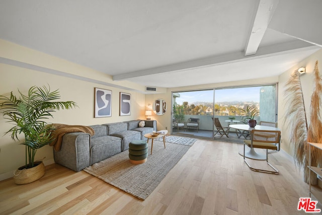 living room with beamed ceiling and light wood-type flooring