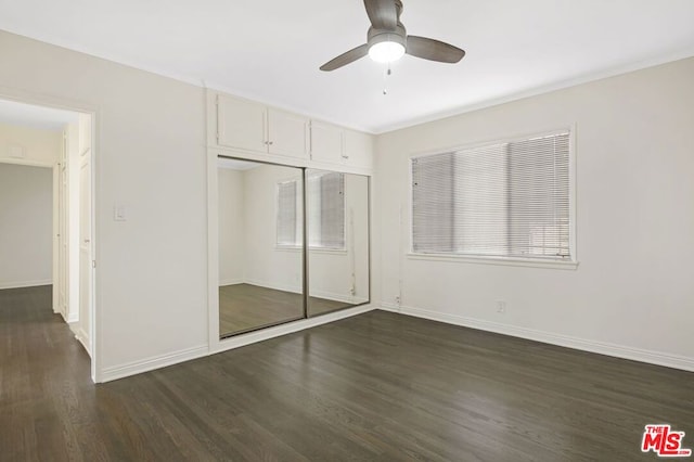 unfurnished bedroom with dark hardwood / wood-style flooring, a closet, and ceiling fan