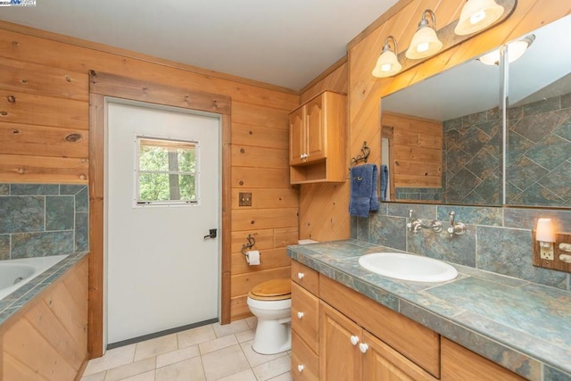 bathroom with tasteful backsplash, tile patterned floors, vanity, wooden walls, and toilet