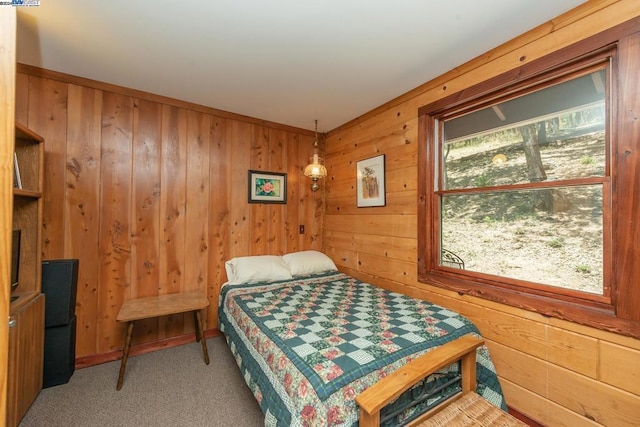 bedroom with wooden walls and carpet floors