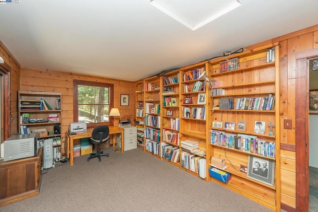 carpeted office featuring wood walls