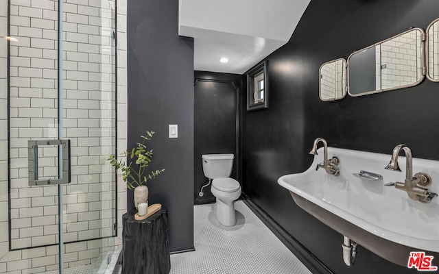 bathroom with toilet, tile patterned flooring, sink, and walk in shower