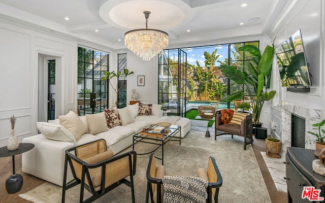 living room featuring a high end fireplace, coffered ceiling, and a chandelier