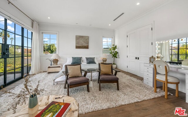 sitting room with hardwood / wood-style flooring and crown molding