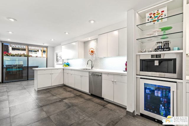 kitchen with backsplash, white cabinets, sink, wine cooler, and stainless steel appliances