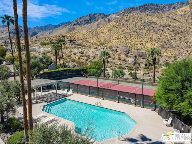 view of pool featuring a mountain view and tennis court