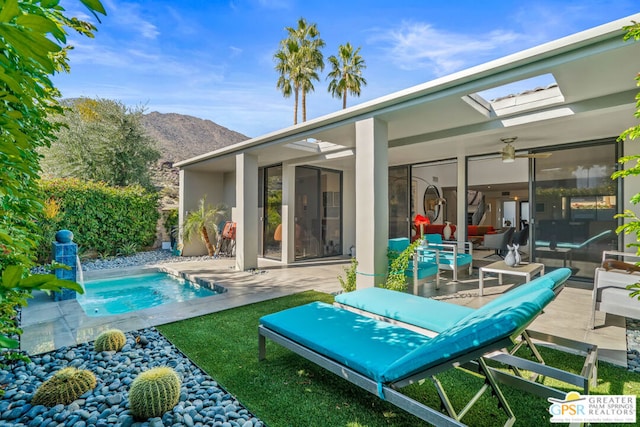 back of house with a mountain view, ceiling fan, and a patio area