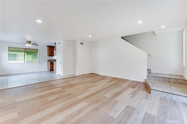 unfurnished living room featuring ceiling fan and light wood-type flooring