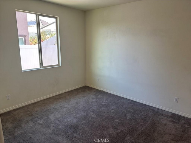 unfurnished room featuring dark colored carpet