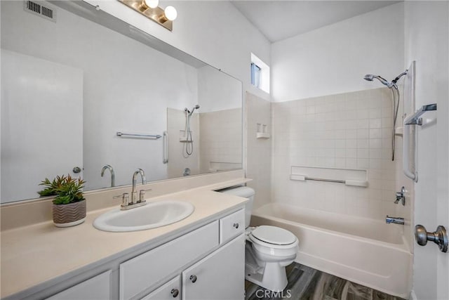 full bathroom with vanity, wood-type flooring, tiled shower / bath combo, and toilet