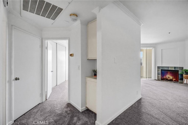 hallway with dark colored carpet and crown molding