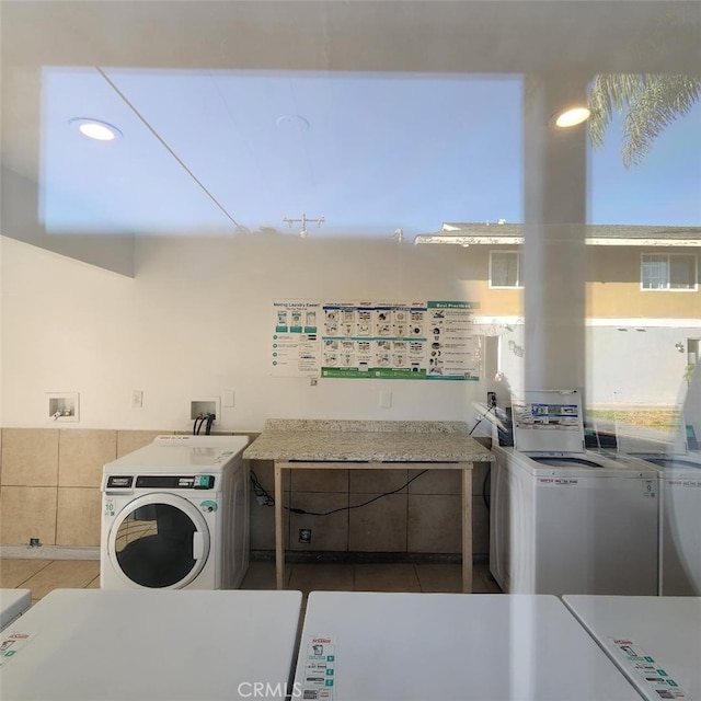 washroom with dark tile patterned floors and washer and clothes dryer