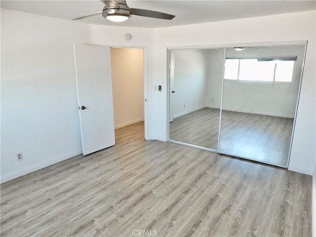 unfurnished bedroom featuring ceiling fan, light wood-type flooring, and a closet