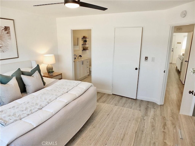 bedroom featuring ensuite bath, ceiling fan, and light hardwood / wood-style flooring