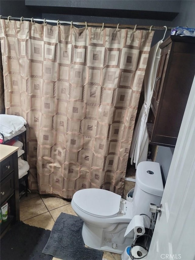 bathroom with tile patterned flooring, vanity, and toilet