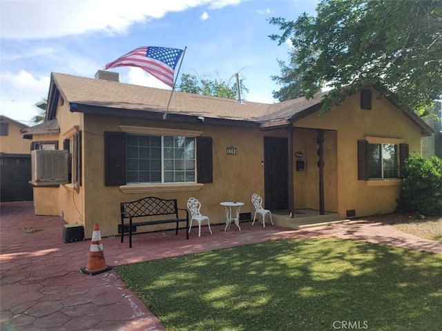 back of property with a yard, central AC unit, and a patio area