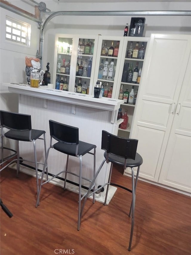 bar featuring white cabinets and dark hardwood / wood-style flooring