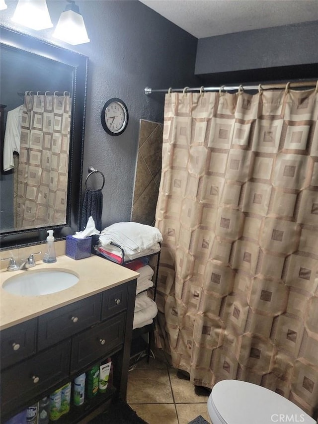 bathroom featuring tile patterned floors, curtained shower, vanity, and toilet