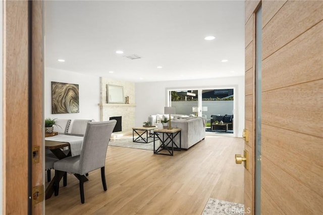 office space with recessed lighting, a fireplace, and light wood-style floors