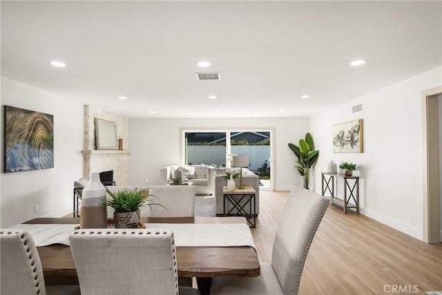 dining room featuring a fireplace and light wood-type flooring