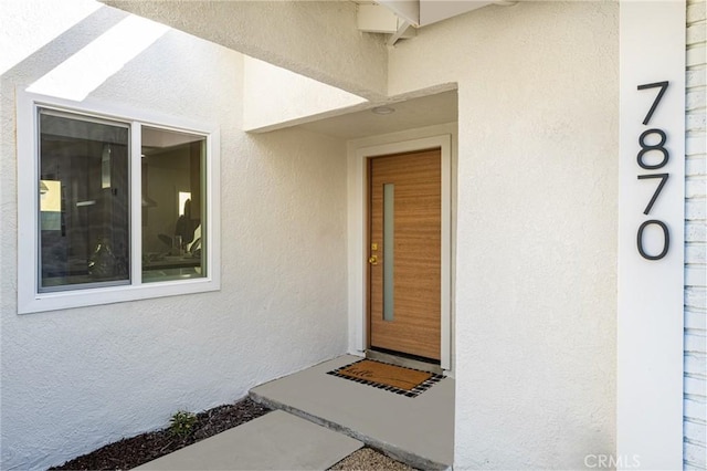 doorway to property with stucco siding