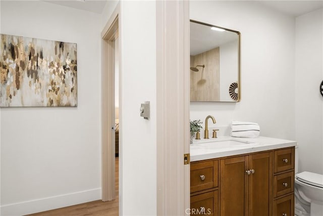 bathroom with vanity, a shower, hardwood / wood-style floors, and toilet