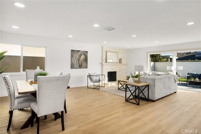 dining room featuring a fireplace and light hardwood / wood-style flooring