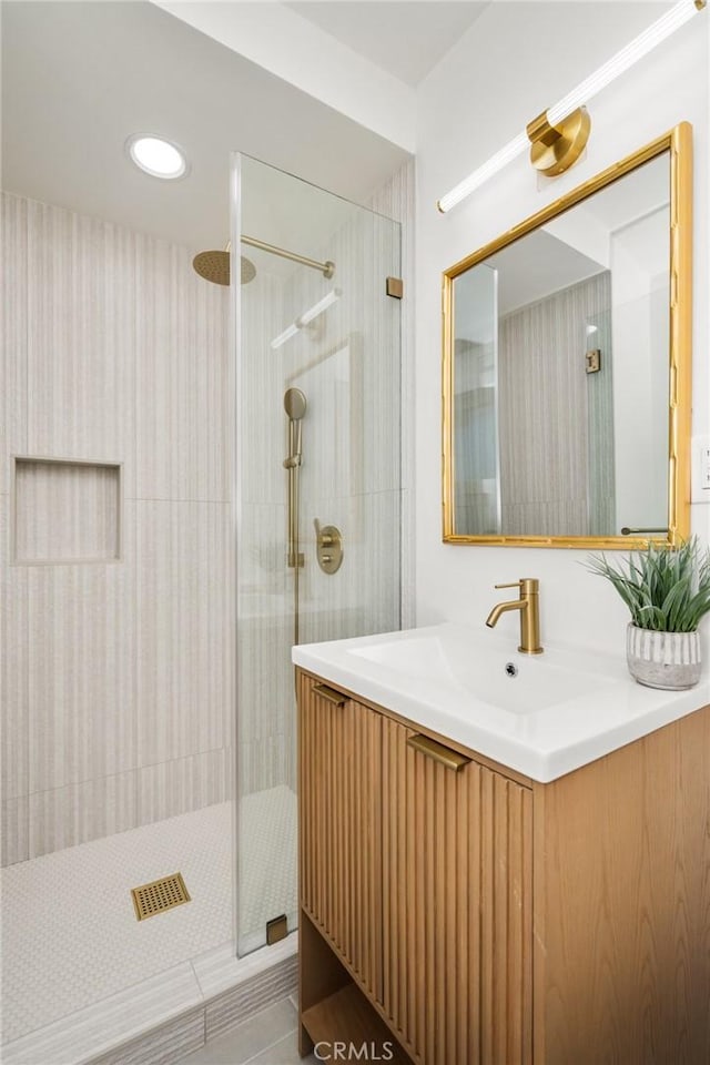 full bath featuring a tile shower and vanity