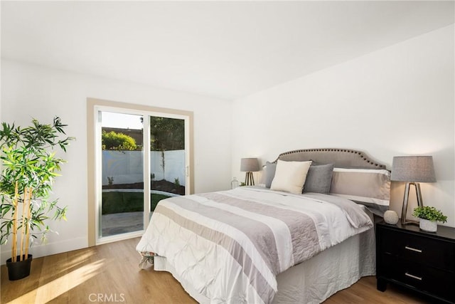 bedroom with access to exterior and light wood-type flooring