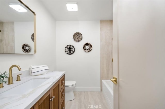 full bathroom featuring toilet, baseboards, and vanity