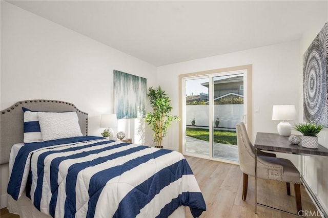 bedroom featuring access to outside and wood finished floors