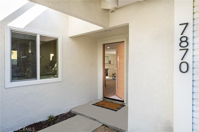 view of exterior entry with stucco siding