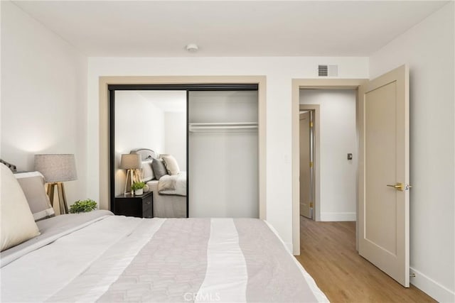 bedroom featuring light hardwood / wood-style floors and a closet