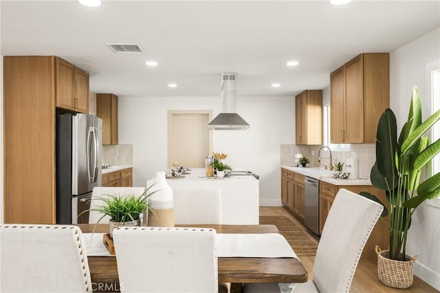 kitchen featuring a sink, visible vents, light countertops, appliances with stainless steel finishes, and a center island