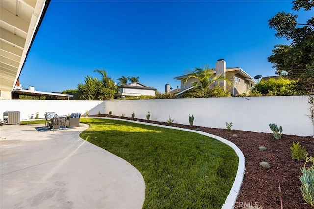 view of yard featuring a fenced backyard, central AC, and a patio