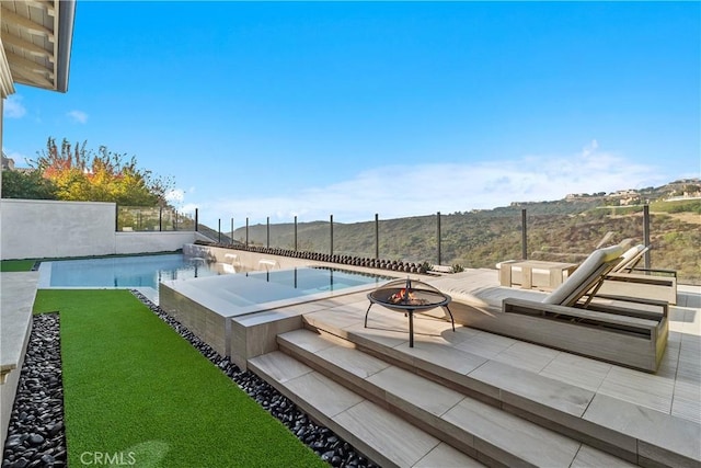 view of swimming pool featuring a patio area and a fire pit