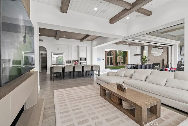 living room featuring beam ceiling and light wood-type flooring