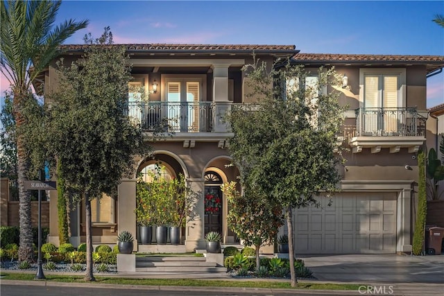 mediterranean / spanish house featuring a balcony and a garage