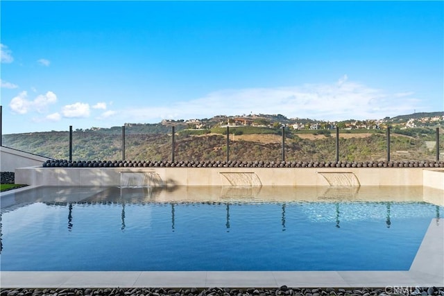 view of swimming pool with pool water feature