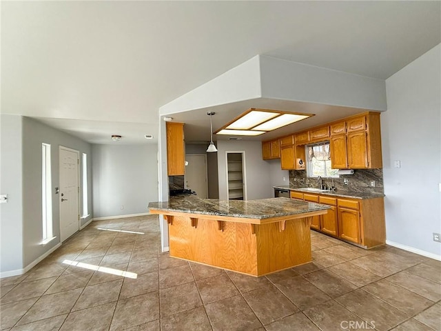35777 Rd 606, Raymond, CA 93653 - kitchen with a peninsula, brown cabinetry, decorative backsplash, and baseboards