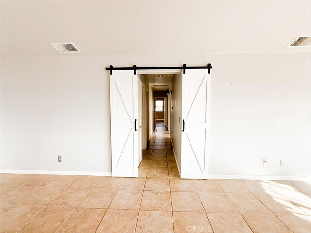 35777 Rd 606, Raymond, CA 93653 - unfurnished room featuring light tile patterned flooring, a barn door, and baseboards