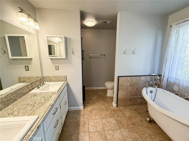 35777 Rd 606, Raymond, CA 93653 - full bath featuring double vanity, a freestanding tub, toilet, baseboards, and tile patterned flooring