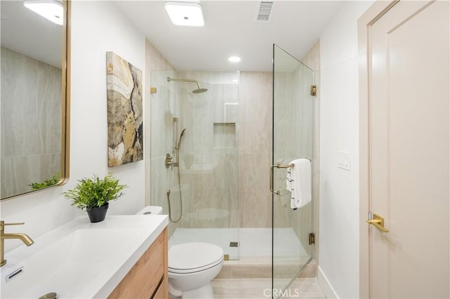 bathroom with vanity, a shower with shower door, and toilet