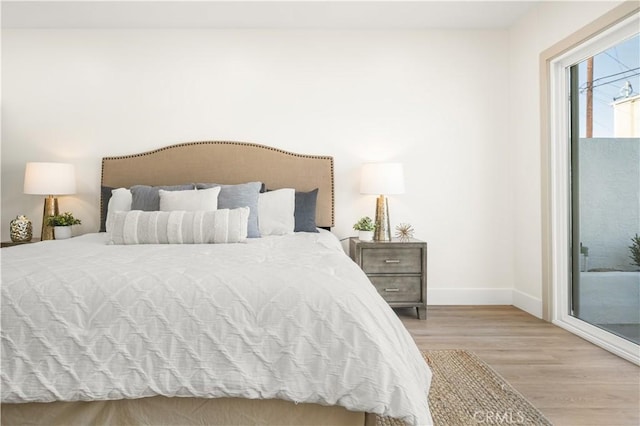 bedroom with access to exterior and light wood-type flooring