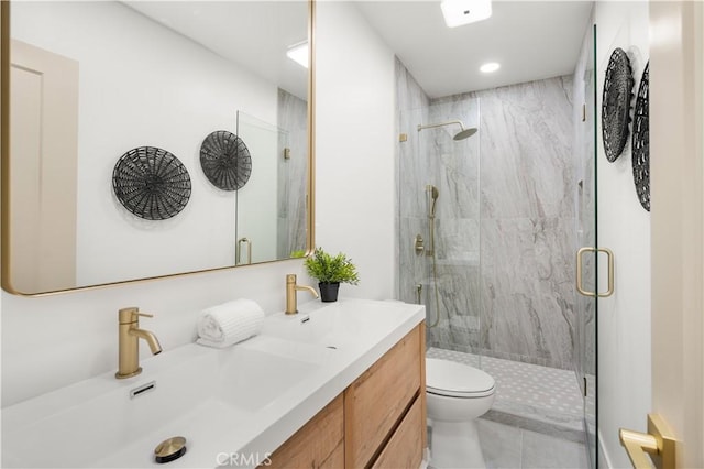 bathroom featuring a shower with door, vanity, and toilet