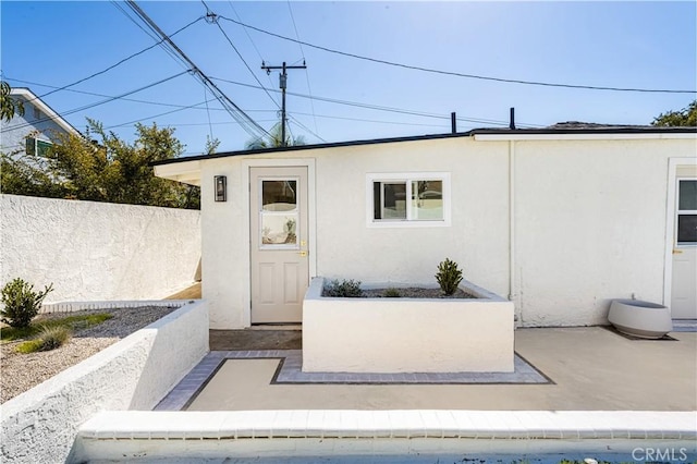 view of exterior entry with a patio area