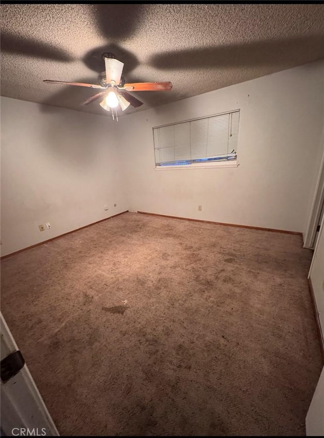 carpeted spare room featuring ceiling fan and a textured ceiling