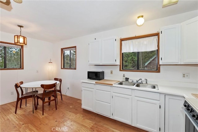 kitchen featuring white cabinetry, pendant lighting, and light hardwood / wood-style floors