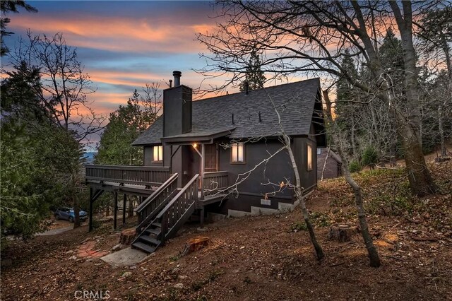 back house at dusk with a deck