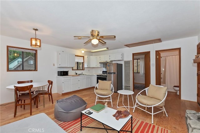 living room featuring light wood-type flooring and ceiling fan